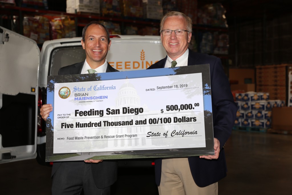 Assemblymember Brian Maienschein and CEO of Feeding San Diego holding check