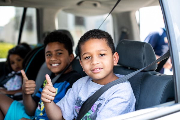 Boys in car with thumbs up sign