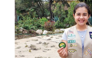 Smiling Girl Scout holds her Climate Controller patch