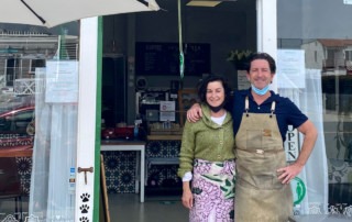 Owners of small goods stand smiling outside their restaurant in La Jolla