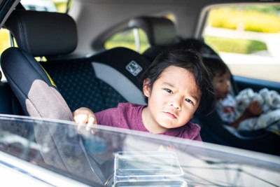 Young boy in back seat of car at Feeding San Diego food distribution