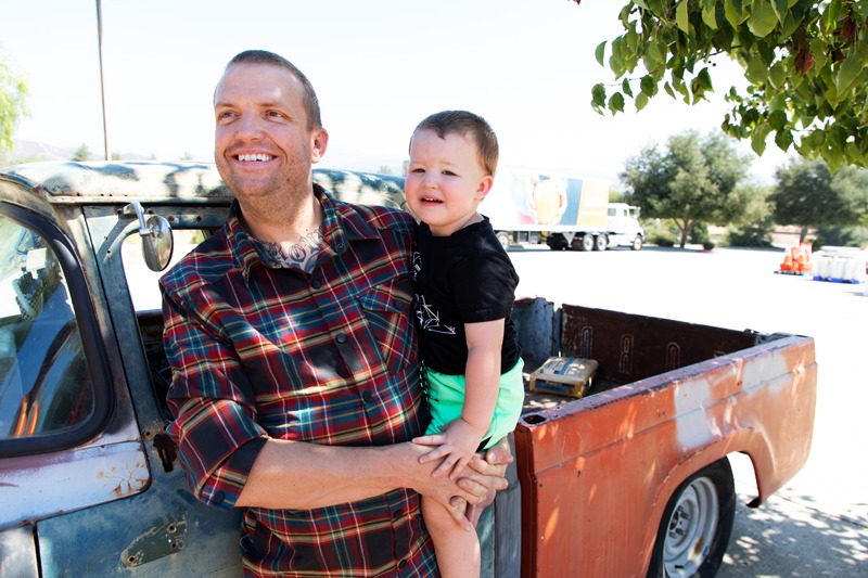 Father and son at Feeding San Diego food distribution smile outside of car