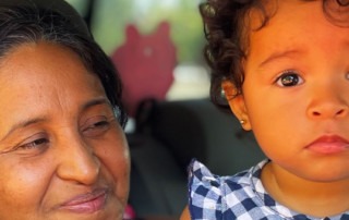 Mother and daughter peer through car window while at Feeding San Diego food distribution