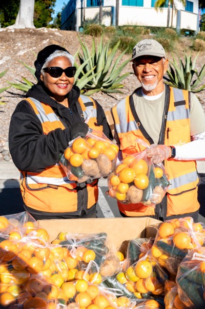 Volunteers hold bags of produce at Feeding San Diego distribution
