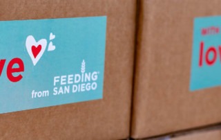 boxes with stickers saying "With Love, from Feeding San Diego"