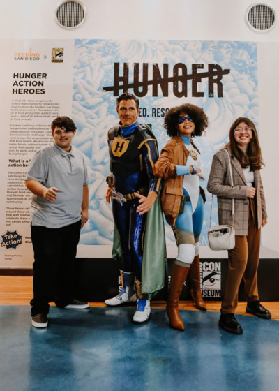 Two teens stand with a man and a woman dressed as superheroes