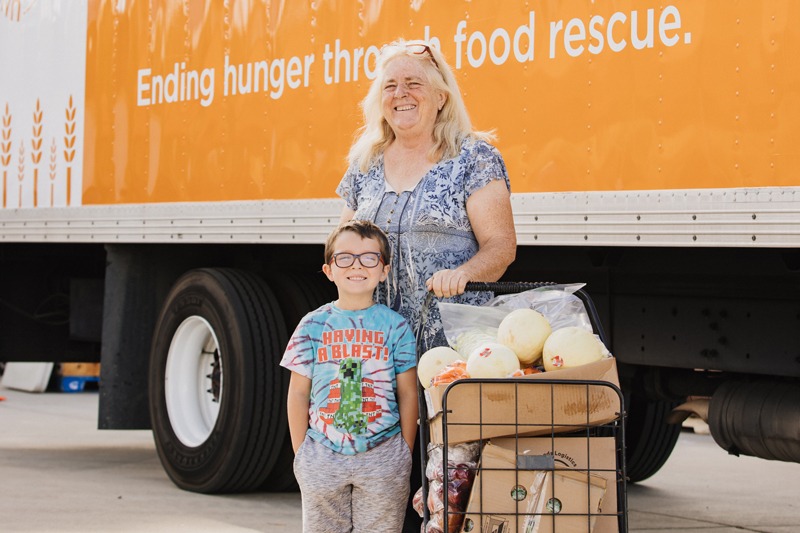 Grandmother and grandson standing at Feeding San Diego food distribution