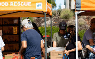 A line of people receiving food at a Feeding San Diego produce pantry run by a teenage volunteer
