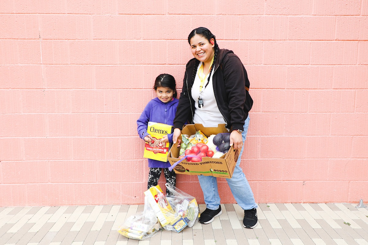 Mother and daughter standing in front of a pink wall