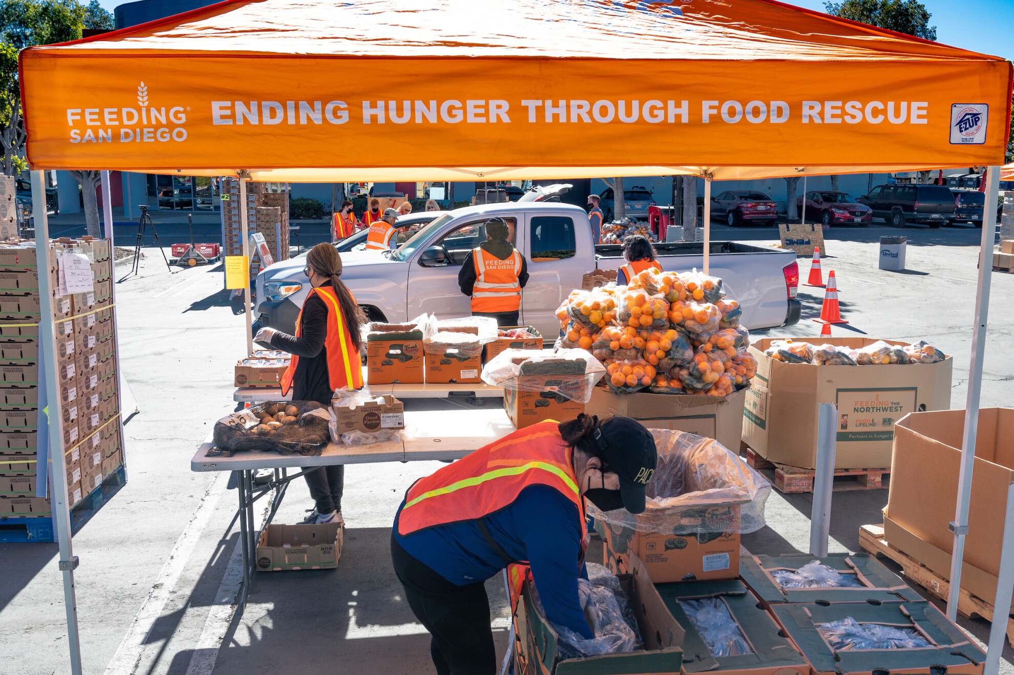 Volunteers placing boxes of food into cars