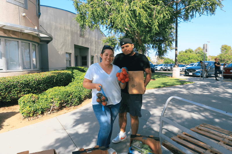 Couples standing with bags of food