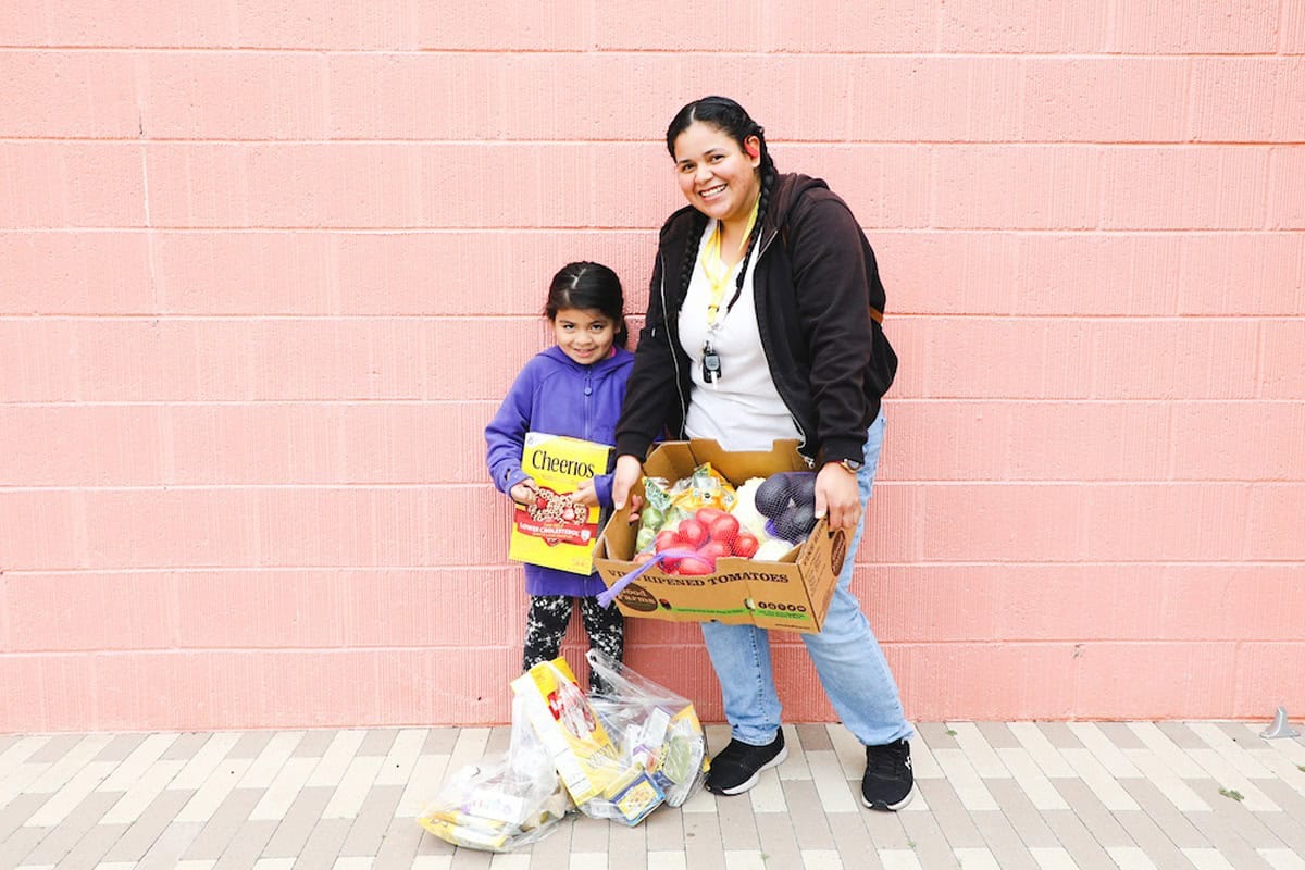 A woman and a young girl holding food
