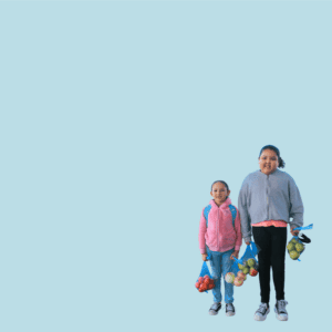 Two sisters standing with bags of fresh produce