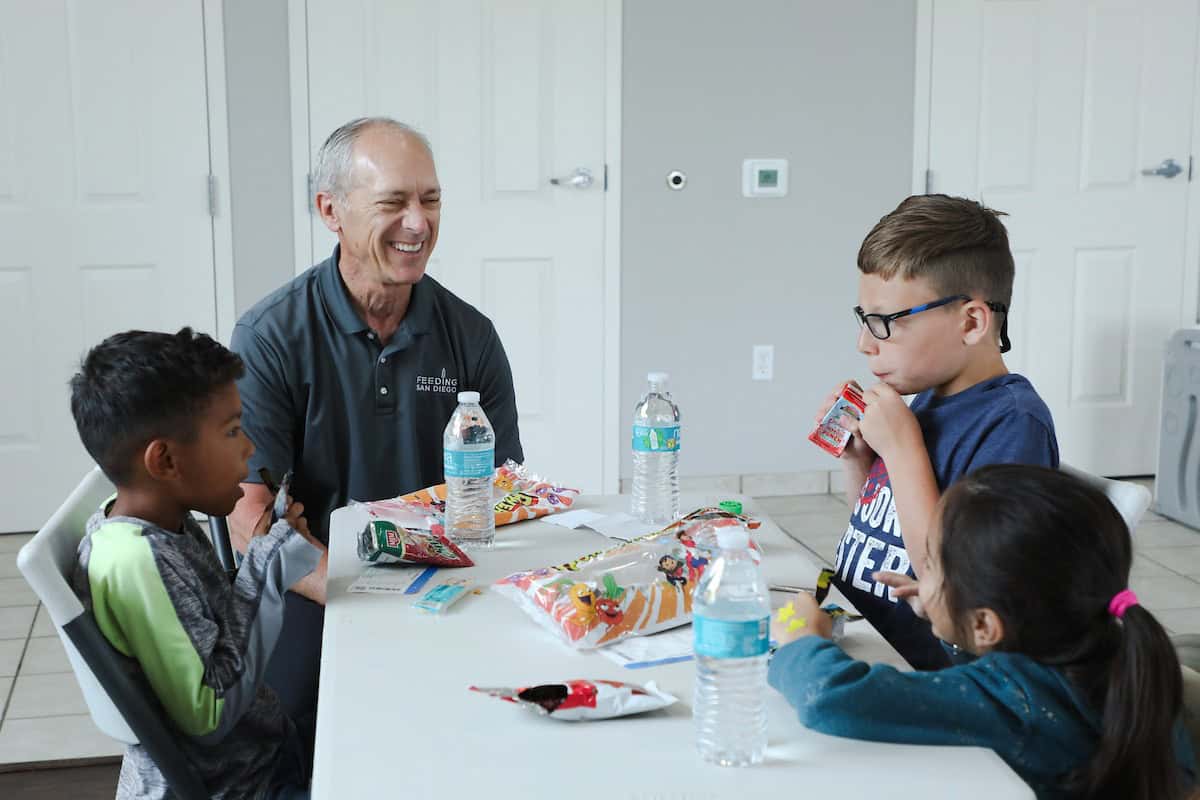 Bob smiling while at table with students