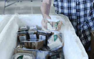 A man picks up food from a box