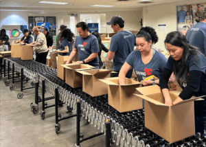Volunteers at an assembly line putting together boxes with shelf-stable items