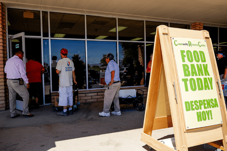 People waiting in line and a sign that says