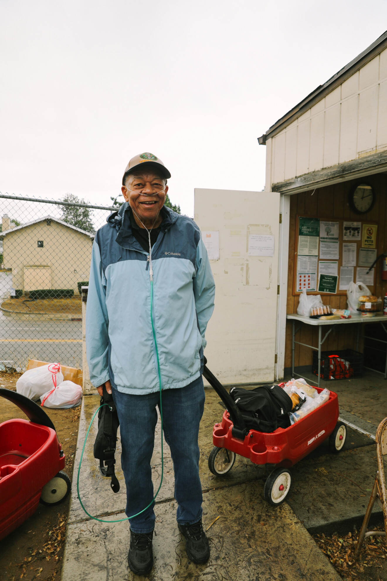 A man wearing an oxygen cannula and pulling a wagon with food