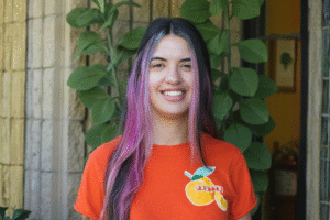 A smiling woman wearing an orange shirt