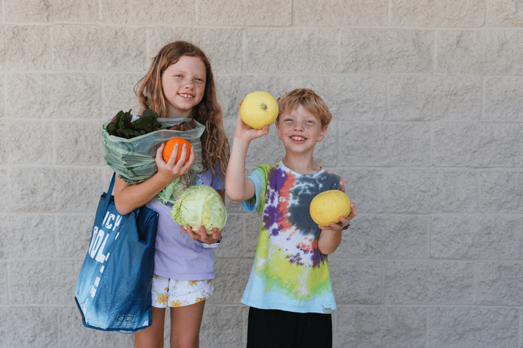 Kids holding up fresh, local produce