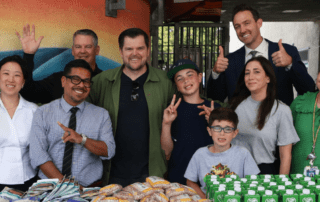 A group of people standing behind a table with food