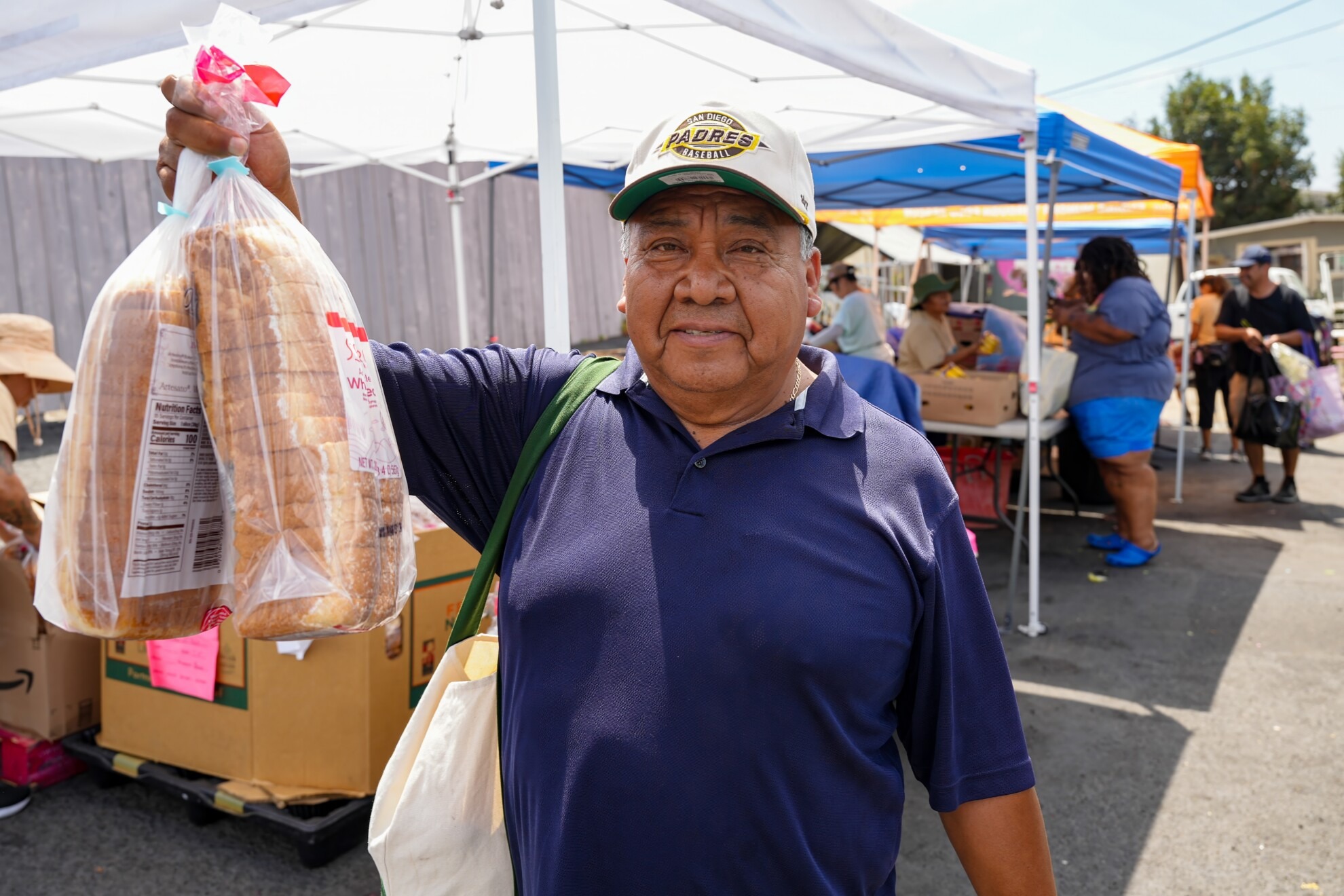 Man holding up bags of bread
